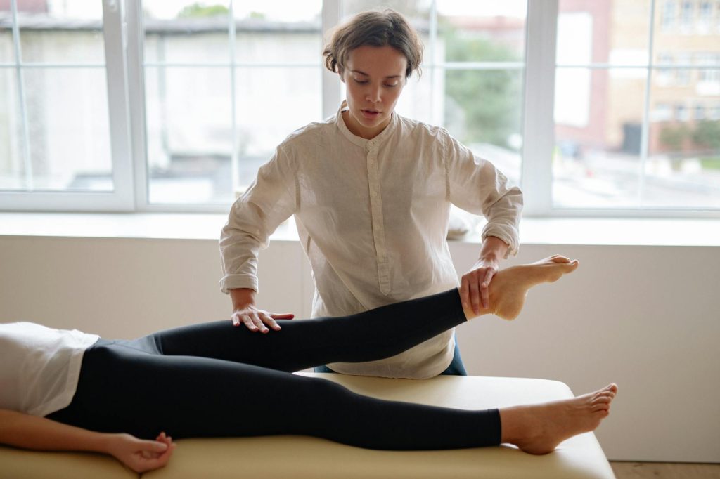woman in white dress shirt holding a person s legs